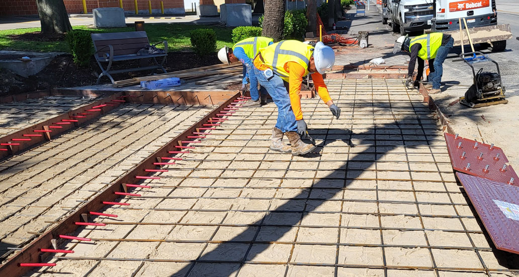 Construction workers tying down rebar to prepare for concrete pouring.